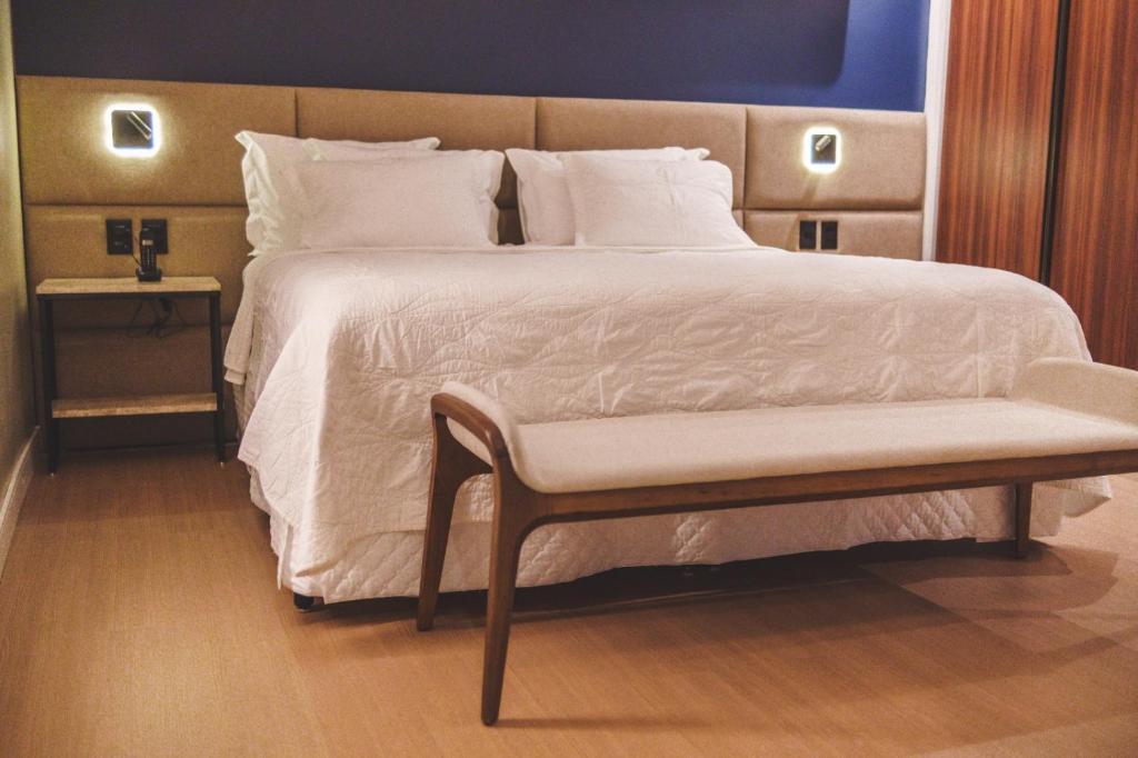 大坎皮纳塞拉诺酒店的一间卧室配有一张大床,旁边设有长凳