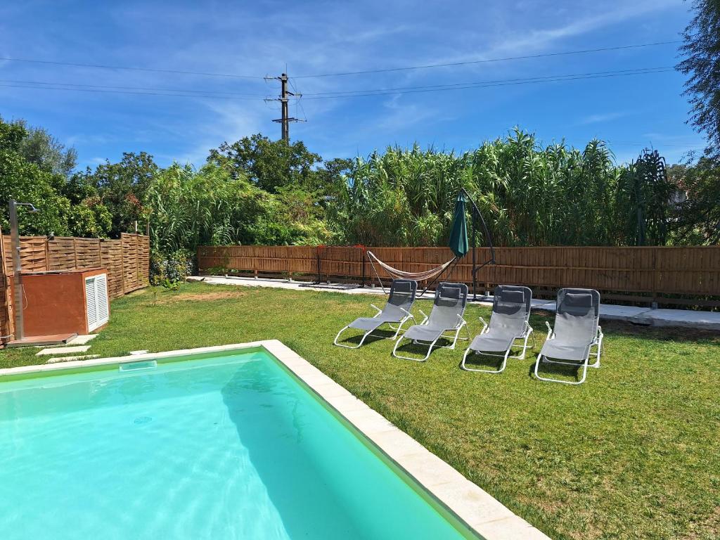 AlcanedeCasa da Ribeira的一个带椅子的庭院和一个游泳池