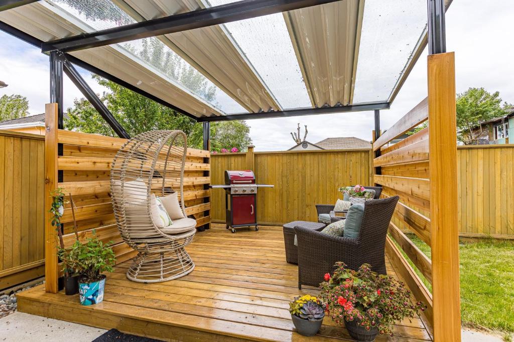 温哥华Home near Downtown Vancouver East@ Joyce Skytrain的木制甲板上设有凉棚和椅子