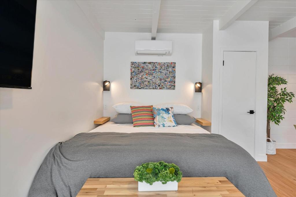 圣卡洛斯Silicon Valley Stay Apartments的一间卧室配有一张床和一张植物桌子