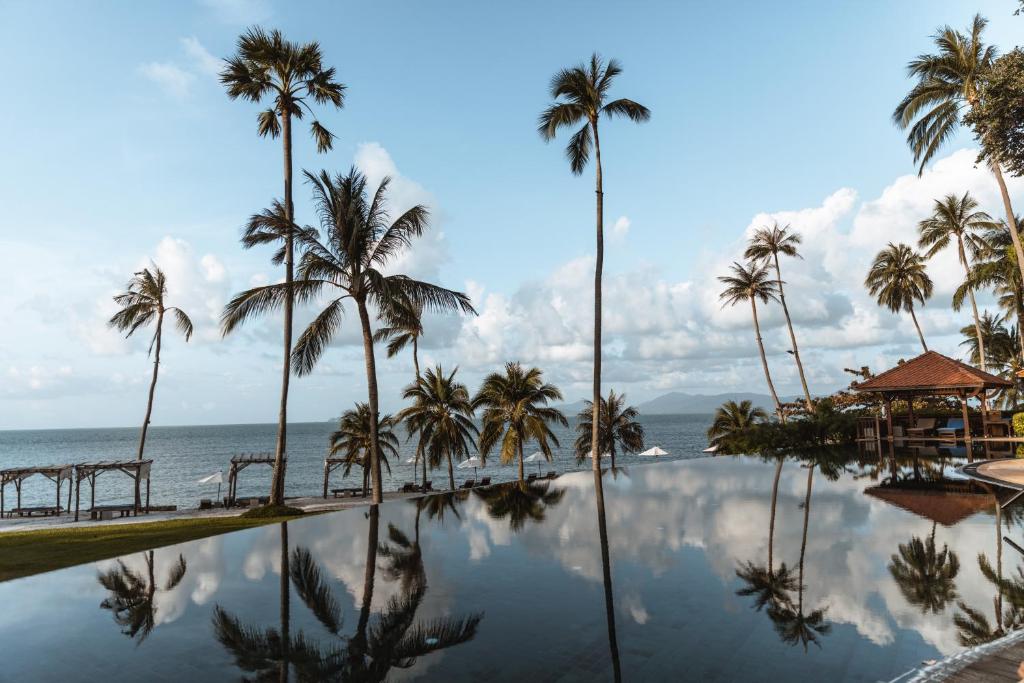 湄南海滩Napasai, A Belmond Hotel, Koh Samui的一座棕榈树和海洋游泳池