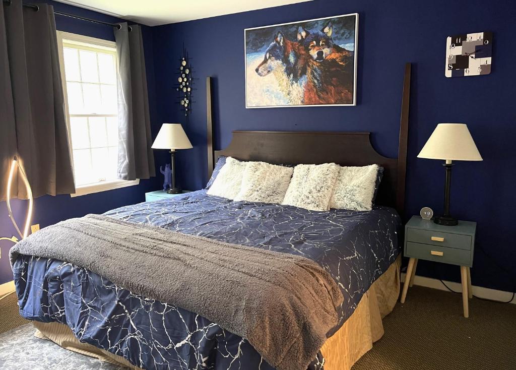 汉考克Mountain View Suite on Jiminy Peak Ski On Off -New的一间卧室配有一张蓝色墙壁的床