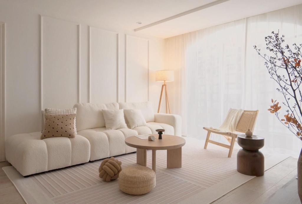 上海太阳民宿的客厅配有白色的沙发和桌子