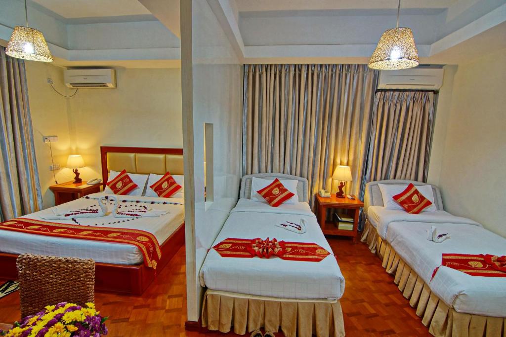 曼德勒雅德纳黄金酒店的酒店客房带两张红色和白色的床单