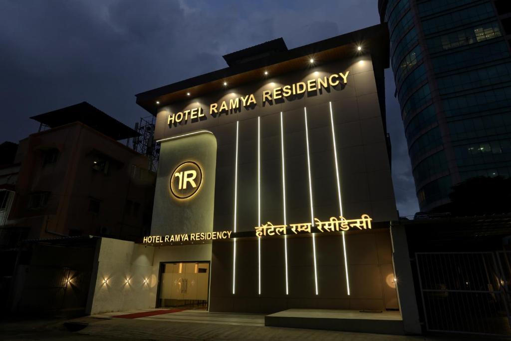纳威孟买Ramya Residency Navi Mumbai的一座带有读取酒店棕榈树的标志的建筑