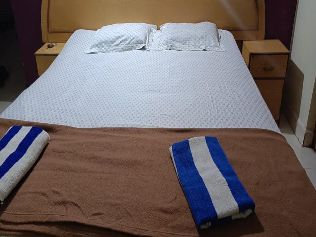 卡纳科纳Dmello Guest House的床上铺有蓝色和白色条纹毛巾