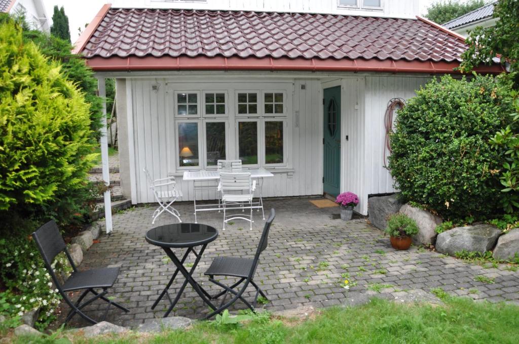滕斯贝格Hyggelig leilighet nær stranden, Tønsberg的房屋前设有带桌椅的天井。