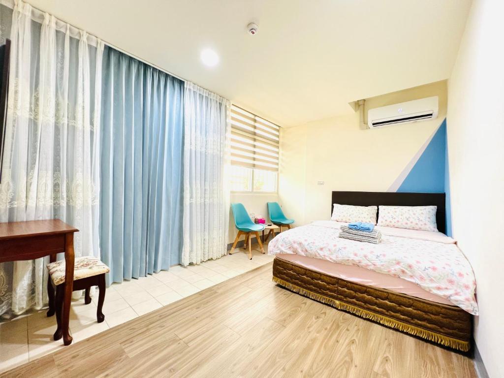 Xingang新港平安民宿的一间卧室配有一张床、一张书桌和窗帘