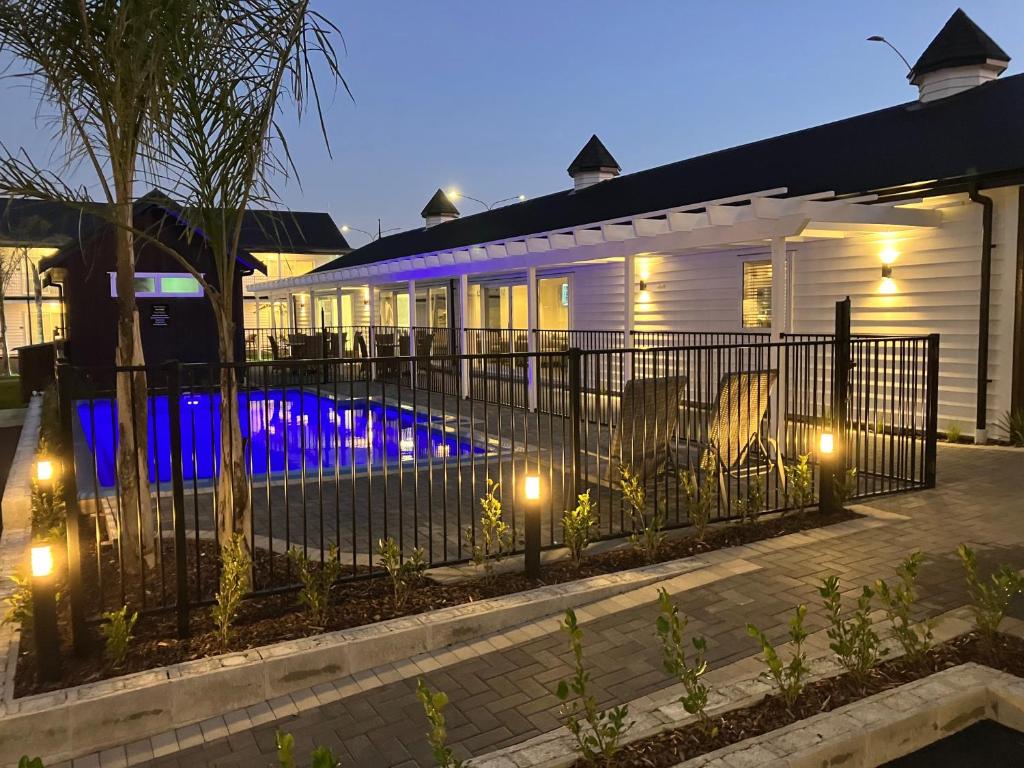 罗托鲁瓦Newina Rotorua的一座带围栏的房子,晚上设有一个游泳池