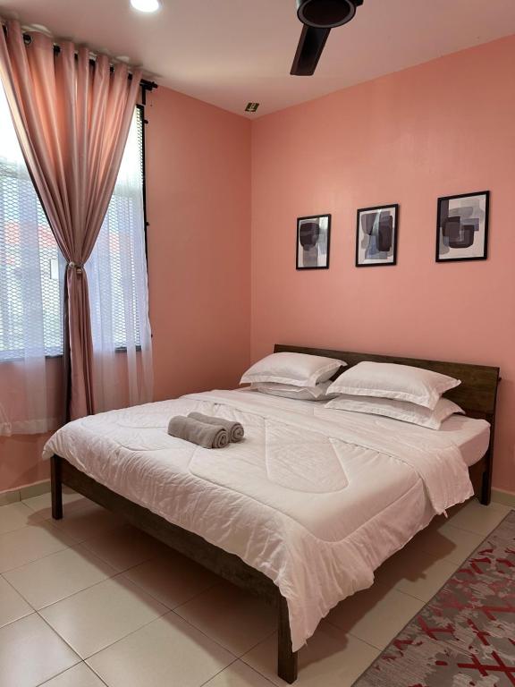 关丹CassaNeyna Homestay Kuantan的卧室配有一张带粉红色墙壁的大床