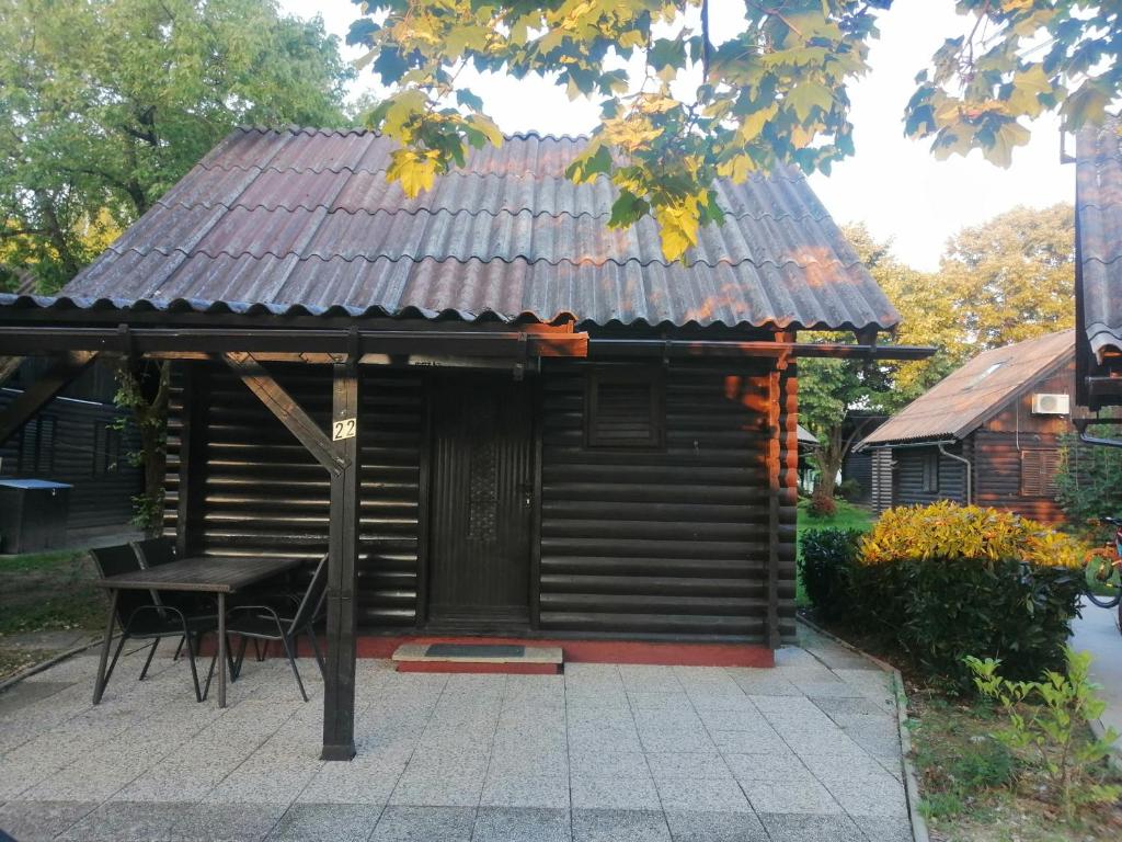 MostecPočitniška hišica Patrik的小屋设有桌子和屋顶