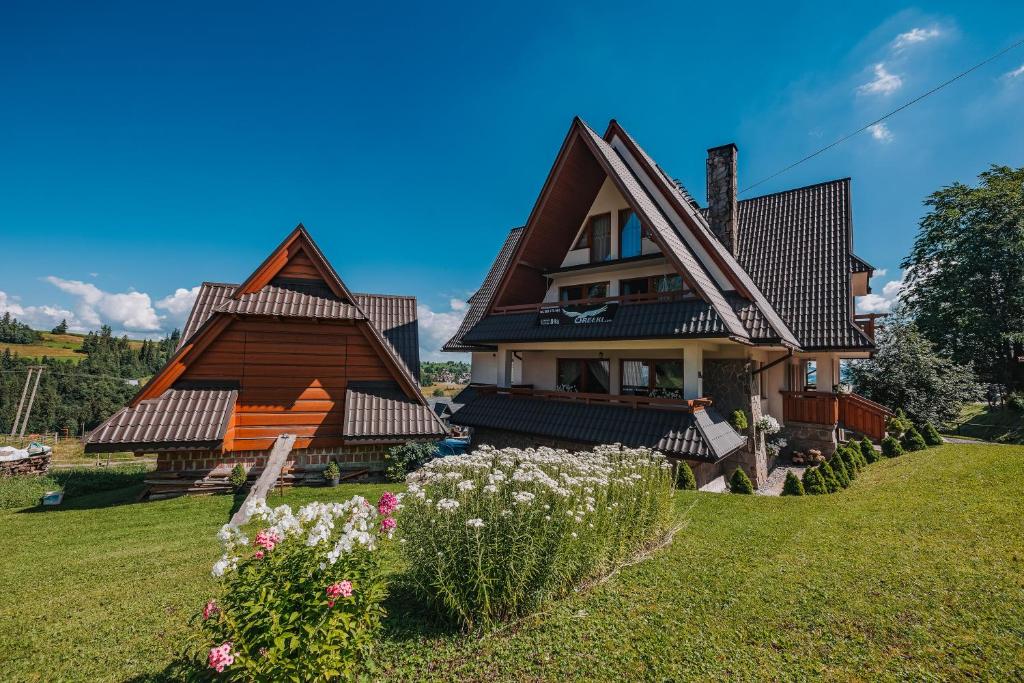布科维纳-塔钱斯卡Dom Wypoczynkowy Orełki的绿色草坪上两顶尖屋顶的房子