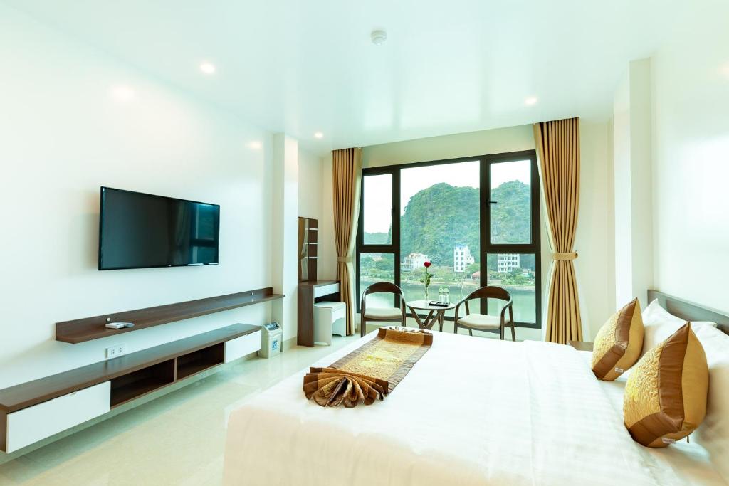 吉婆岛Tung Quang Hotel的卧室配有一张大白色床和平面电视