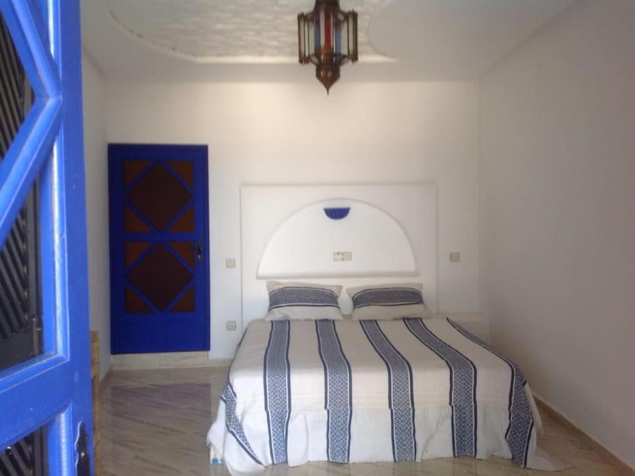 沃利迪耶belle maison vue sur mer的一间卧室配有一张带蓝色门的床