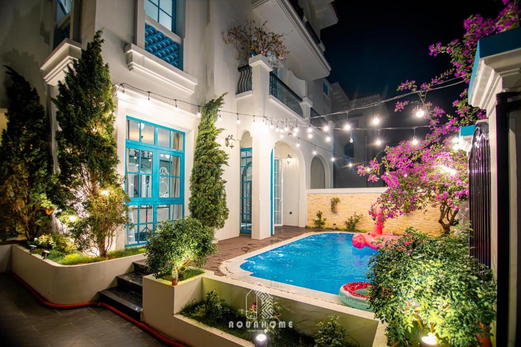 下龙湾The An Nam Villa HaLong的庭院,设有游泳池,位于带灯光的房屋内