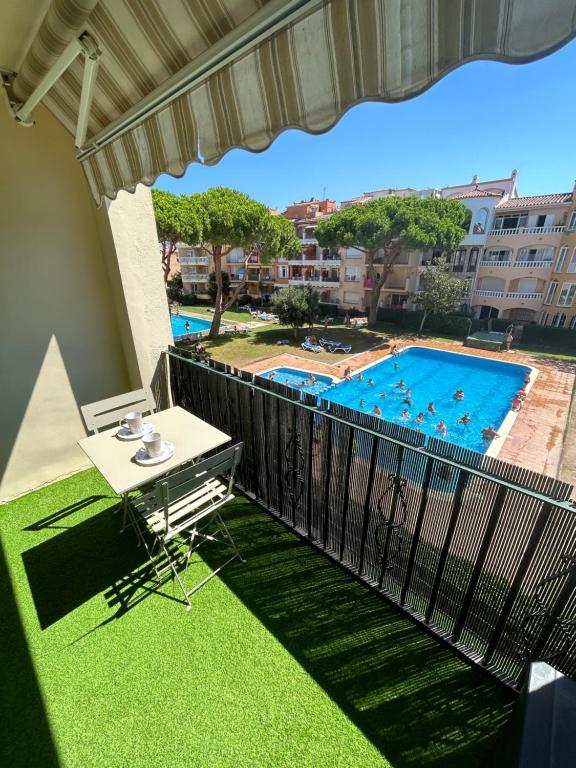 艾姆布里亚布拉瓦Appartement 1 chambre climatisé avec 3 piscines à 200 m de la plage的一个带桌子和游泳池的阳台