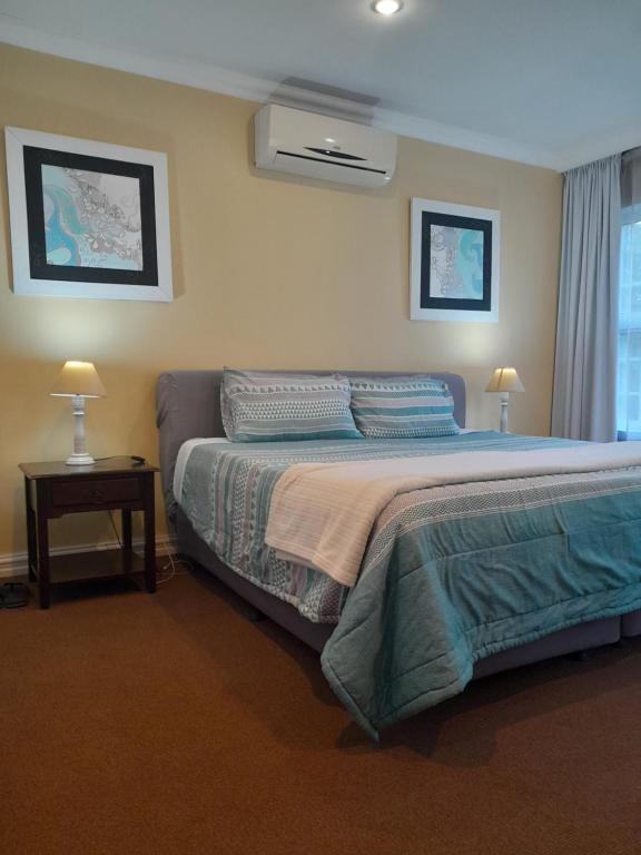 弗里尼欣Sugarbush Accommodation的一间卧室配有一张床和一张带两盏灯的桌子。