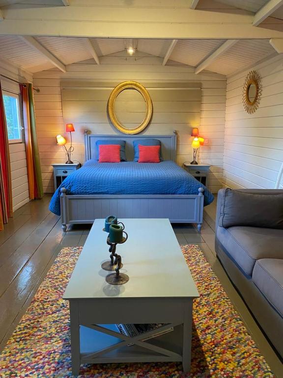 塞扬Tiny House au coeur des Combes的一间卧室配有一张床、一张桌子和一张沙发