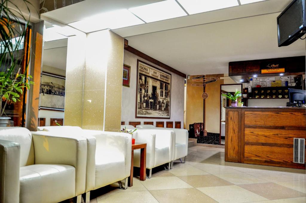 莱斯科瓦茨Hotel Bell的一间设有白色椅子和酒吧的用餐室