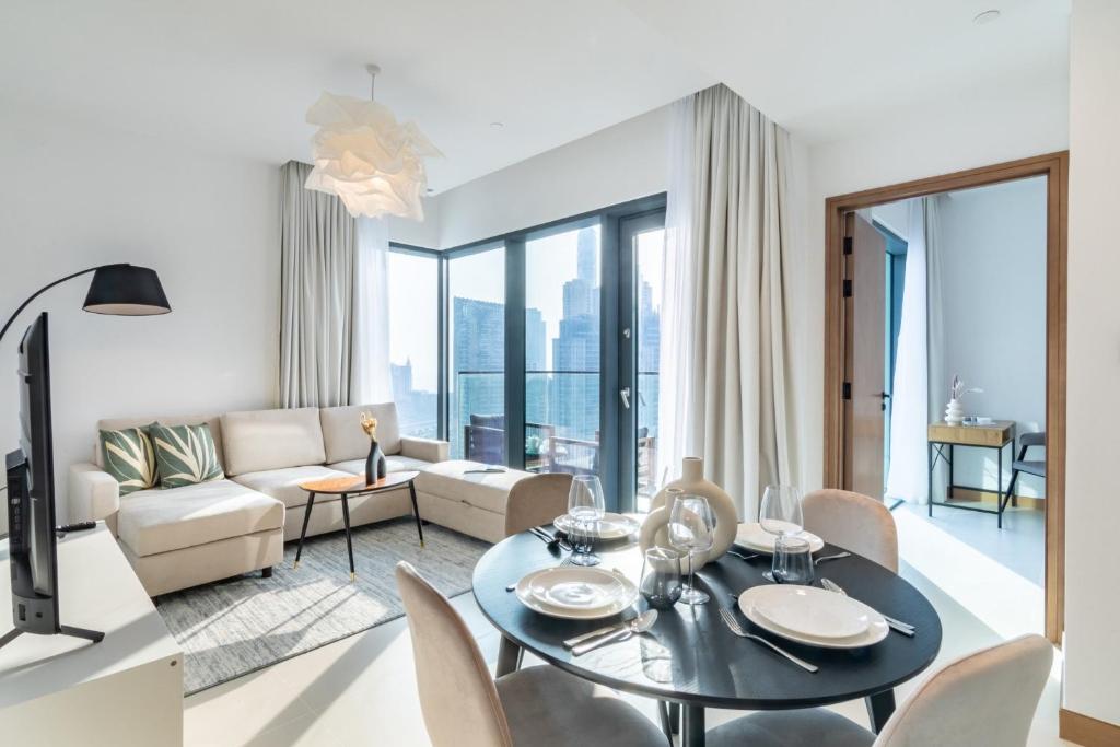 迪拜Welcome Home Apartments - VIDA Marina - Full Marina view - High Floor的客厅配有桌子和沙发