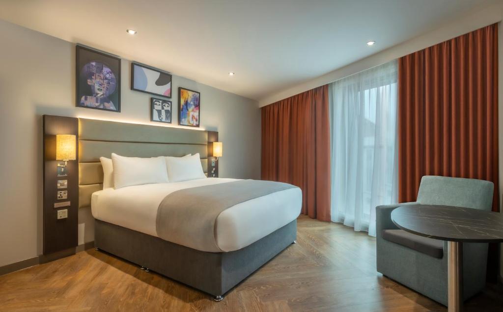 伦敦Maldron Hotel Finsbury Park, London的卧室配有1张床、1张桌子和1把椅子
