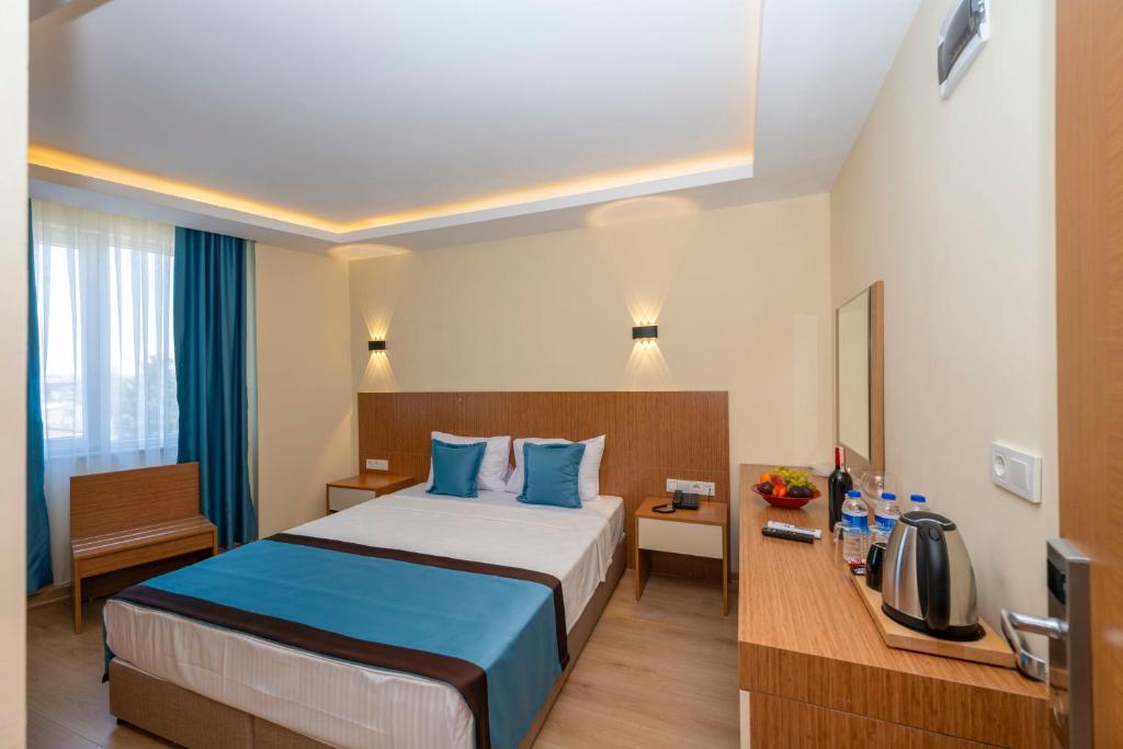 安塔利亚DIAMOND luxury Hotel的酒店客房配有一张带蓝色枕头的大床