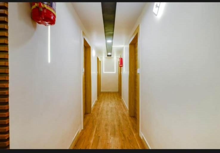 艾哈迈达巴德HOTEL SAFARI INN的走廊设有白色的墙壁和木地板