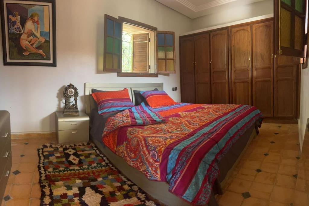马拉喀什dream farm的一间卧室配有一张带色彩缤纷的被子和地毯的床。