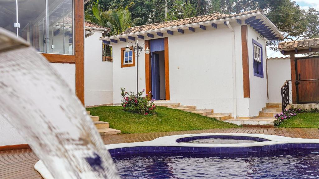 蒂拉登特斯Flat com Piscina no Centro de Tiradentes的房屋前有游泳池的房子