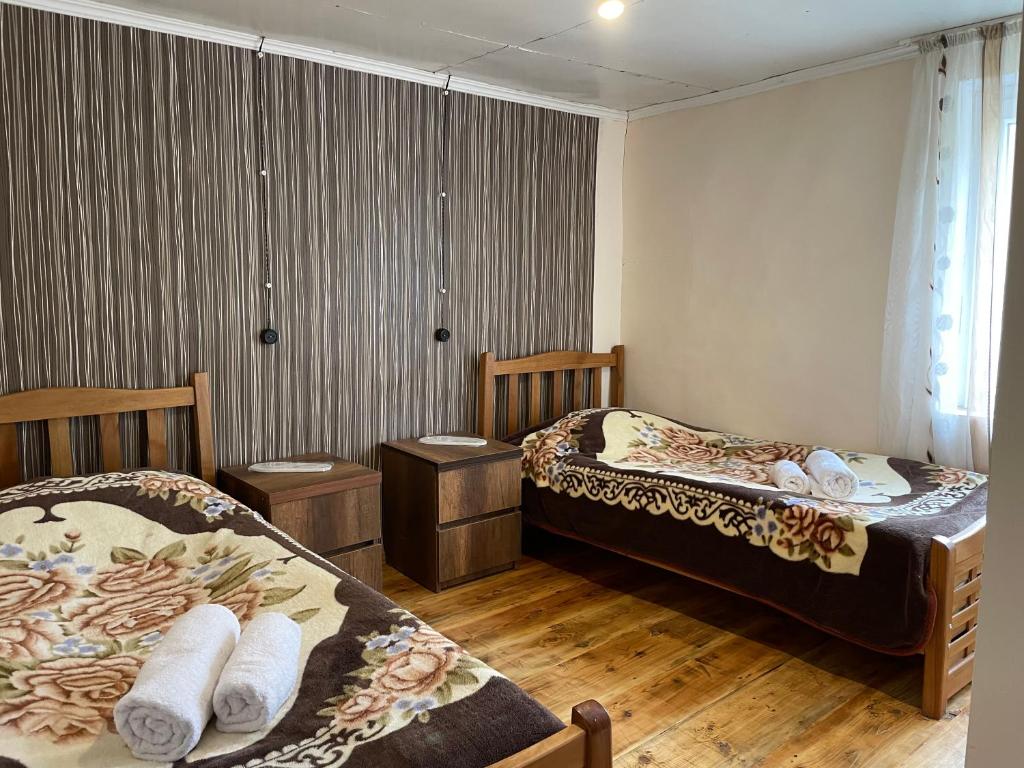 Omalolileo的铺有木地板的客房内的两张床
