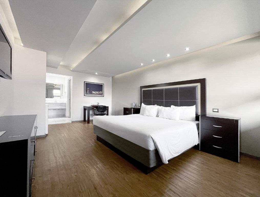 萨尔蒂约昆塔多拉达酒店&套房的配有一张床和一张书桌的酒店客房