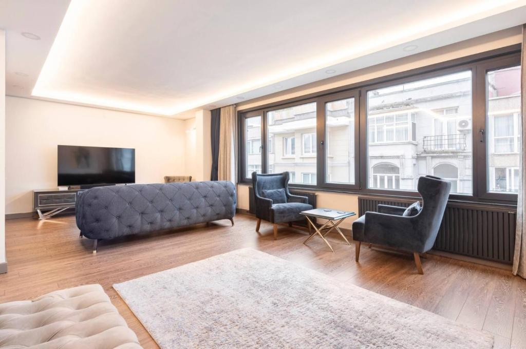 伊斯坦布尔Luxury apartment in the heart of Nisantasi的客厅配有沙发、椅子和电视