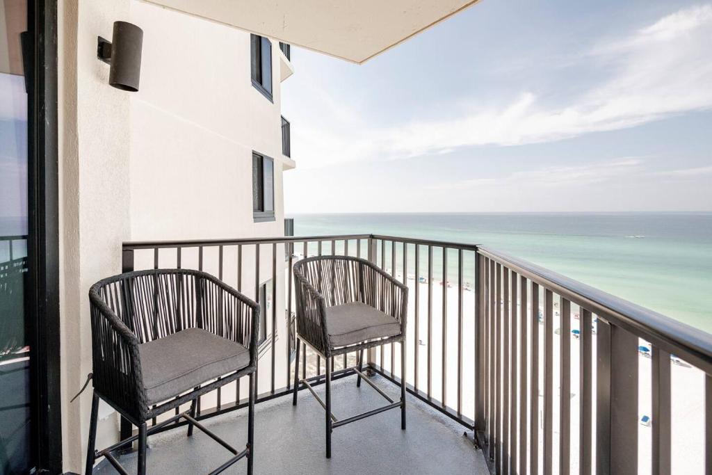 巴拿马城海滩Sunbird Sunsets的两把椅子坐在一个眺望着大海的阳台