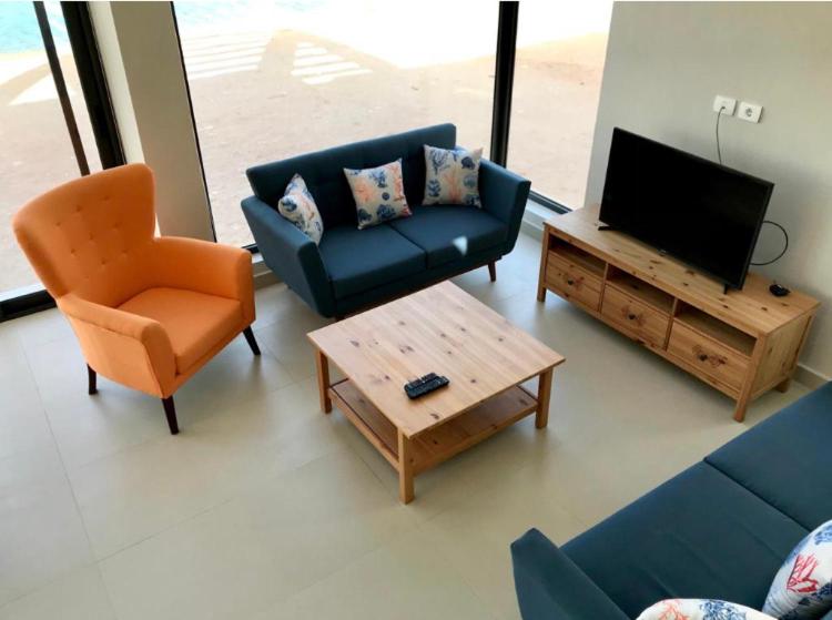 赫尔格达Emos Villa的客厅配有沙发、电视和椅子