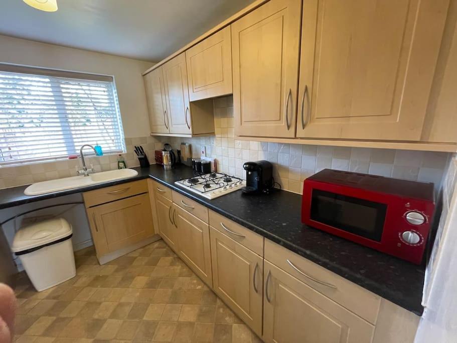 Redhill5 Holborn Spacious Home的厨房在柜台上配有红色微波炉