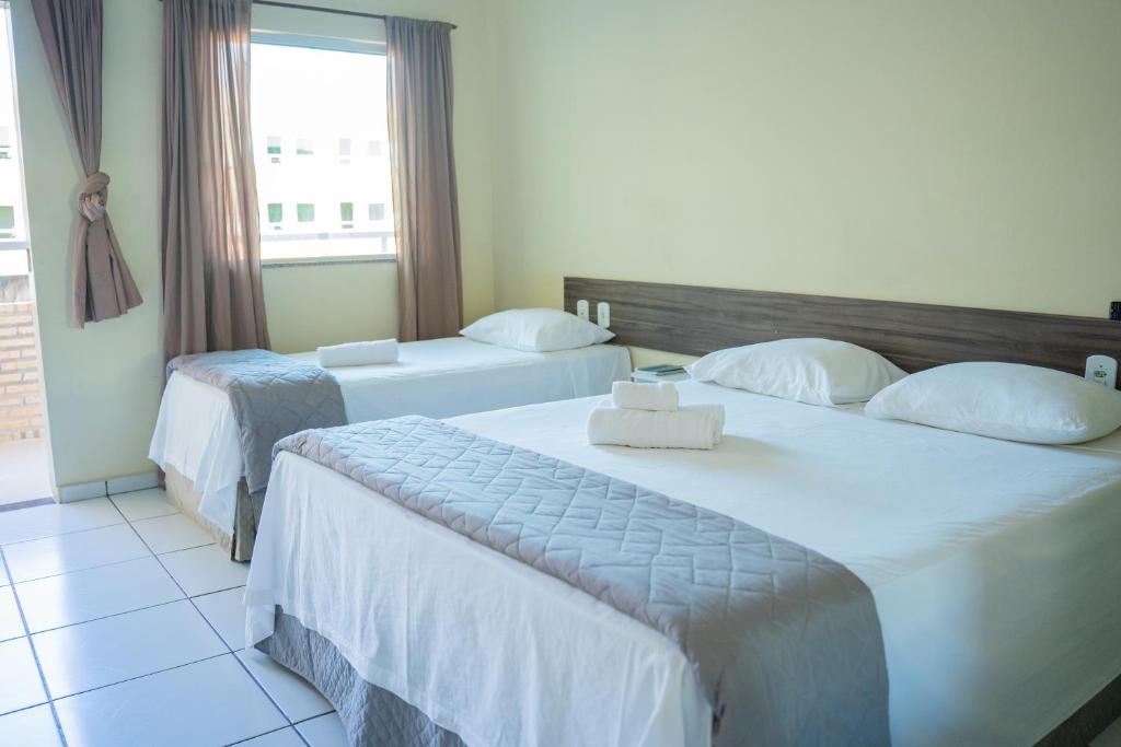巴纳伊巴Pousada Aeroporto的酒店客房设有两张床和窗户。
