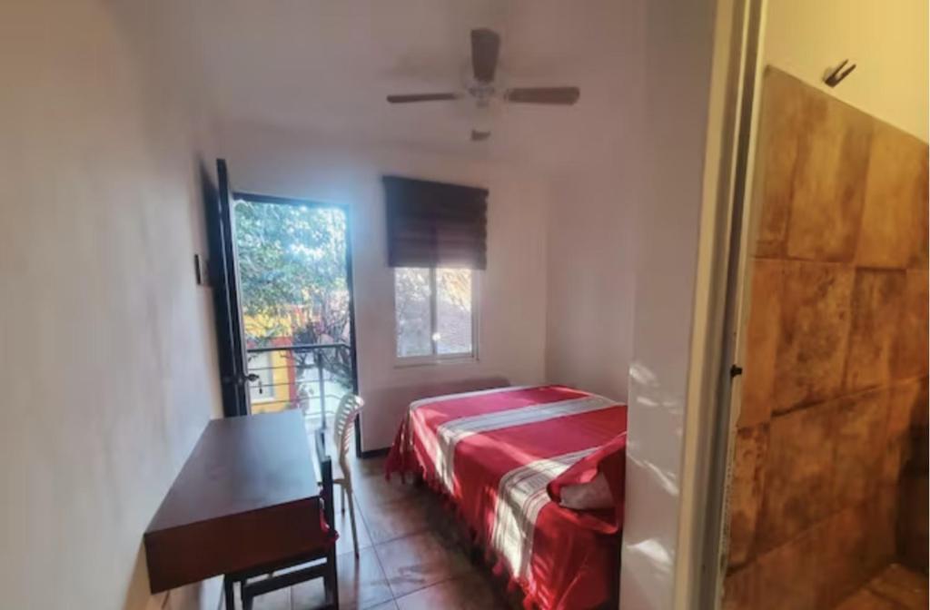 瓦哈卡市Casa Juárez 2的一间卧室配有一张床、一张桌子和一个窗户。