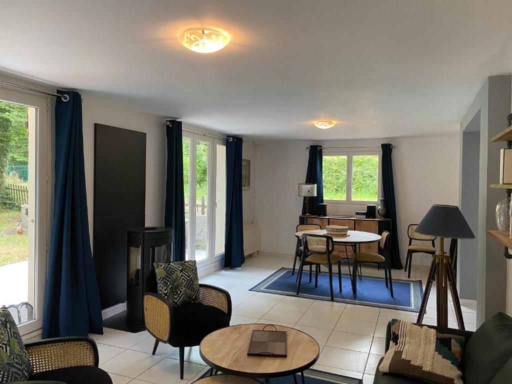勒库德雷·蒙特考克斯Maison dans parc privé, sports et loisirs proche golf du Coudray Montceaux的客厅配有蓝色窗帘和桌椅