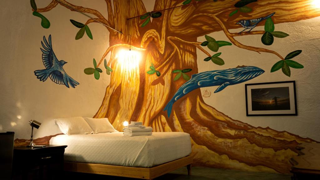 拉巴斯Casa Bahia的卧室墙上挂着树壁画