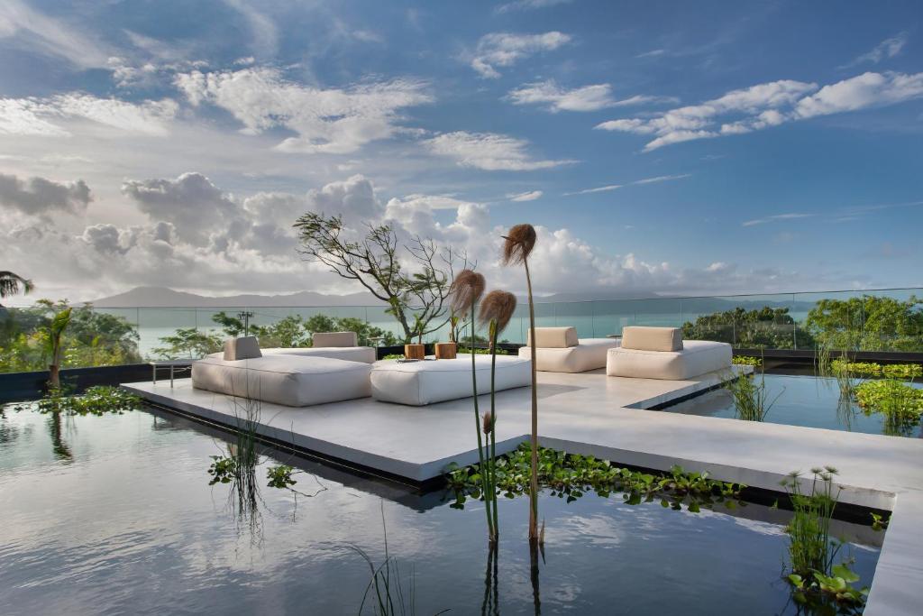 弗洛里亚诺波利斯Fuso Concept Hotel的一间带白色沙发的客厅,享有水景