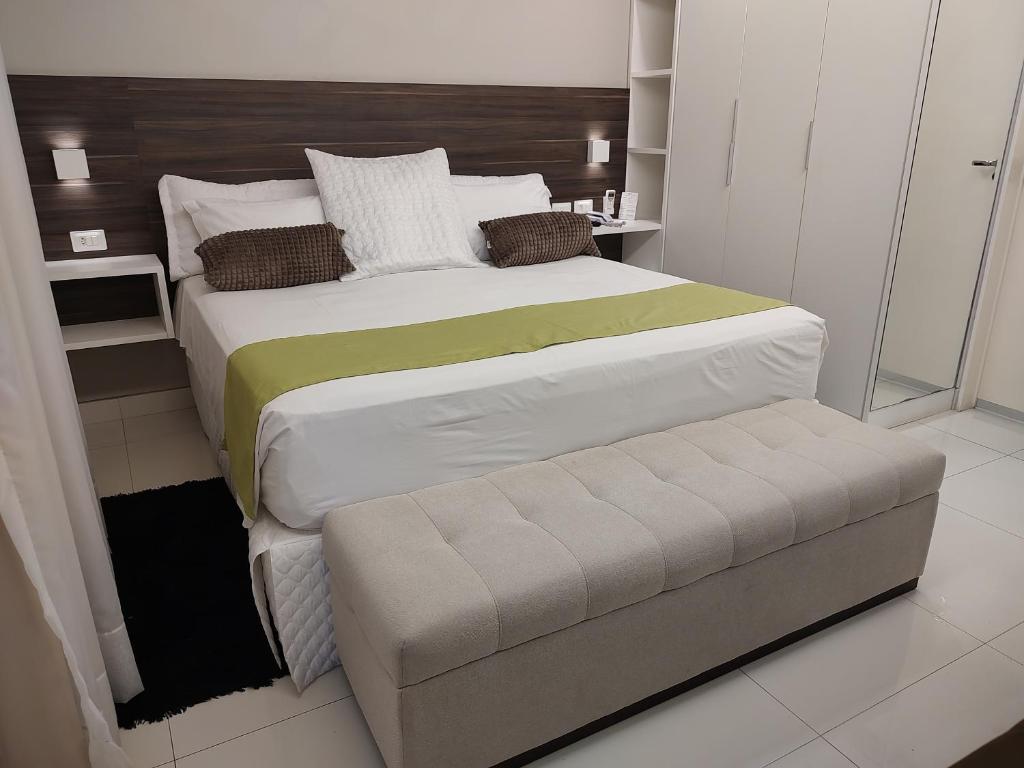 苏鲁宾Pousada Jucazinho的一间卧室配有一张大床和一张长凳