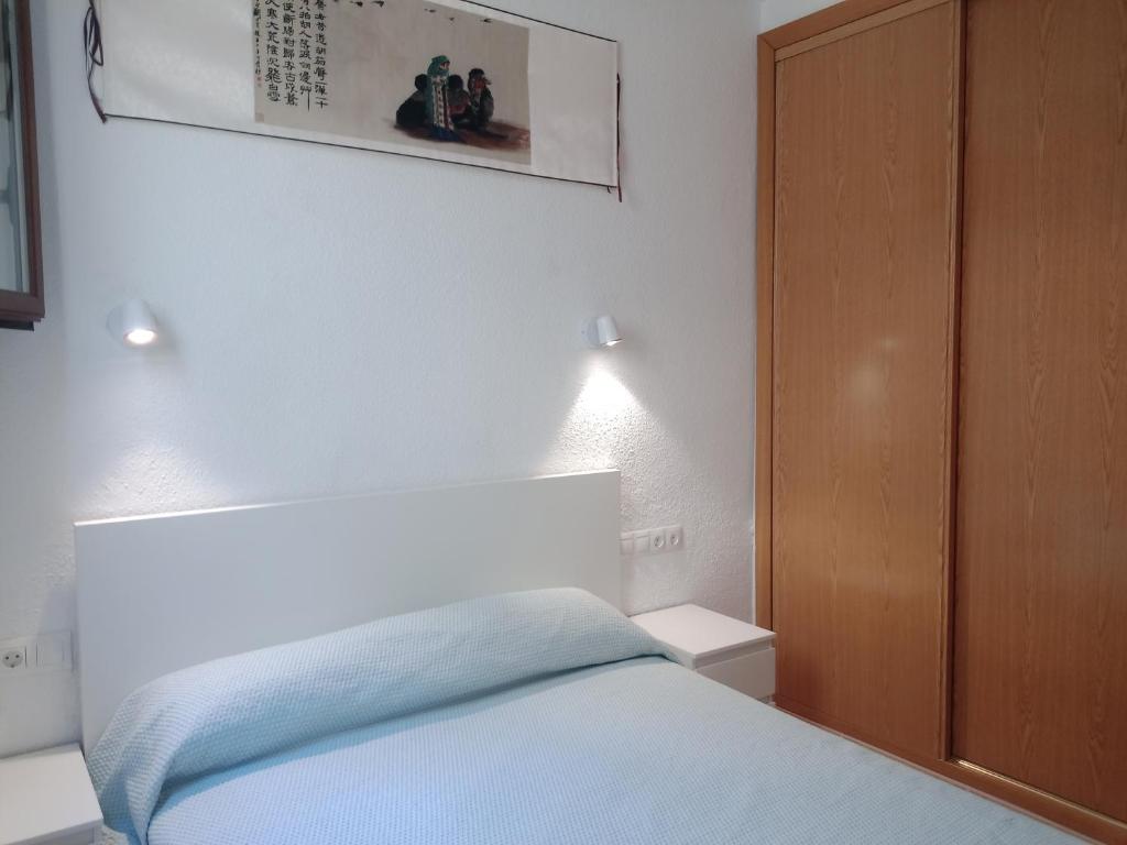 马德里2 dormitorios y el salón tienen aire, Madrid Centro Gran Vía - Plaza de España的一间卧室配有一张床和一个木制橱柜