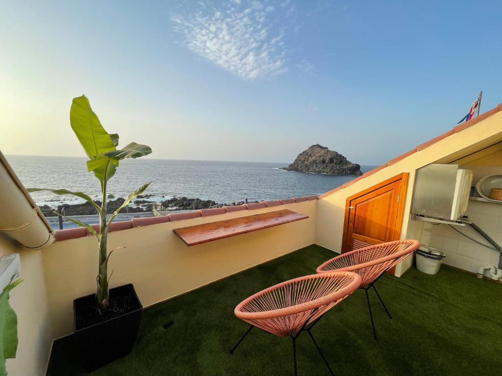 加拉奇科Vv La Joya Del Mar Suites的阳台配有两把椅子,享有海景。