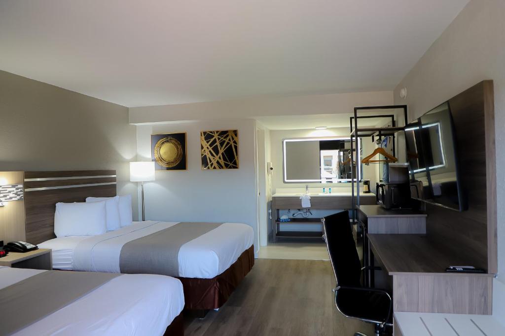 尼德兰机场旅馆的酒店客房配有两张床和一张书桌