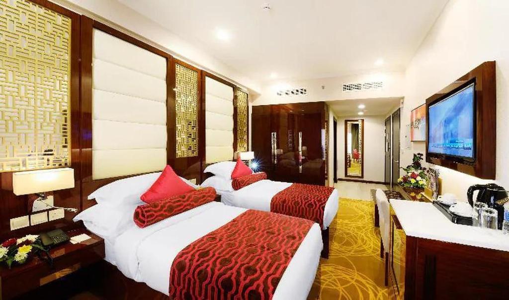 迪拜SKAF HOTEL LLC的酒店客房设有两张床和电视。