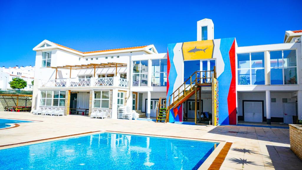 巴勒尔Shark's Lodge的一座房子前面设有游泳池