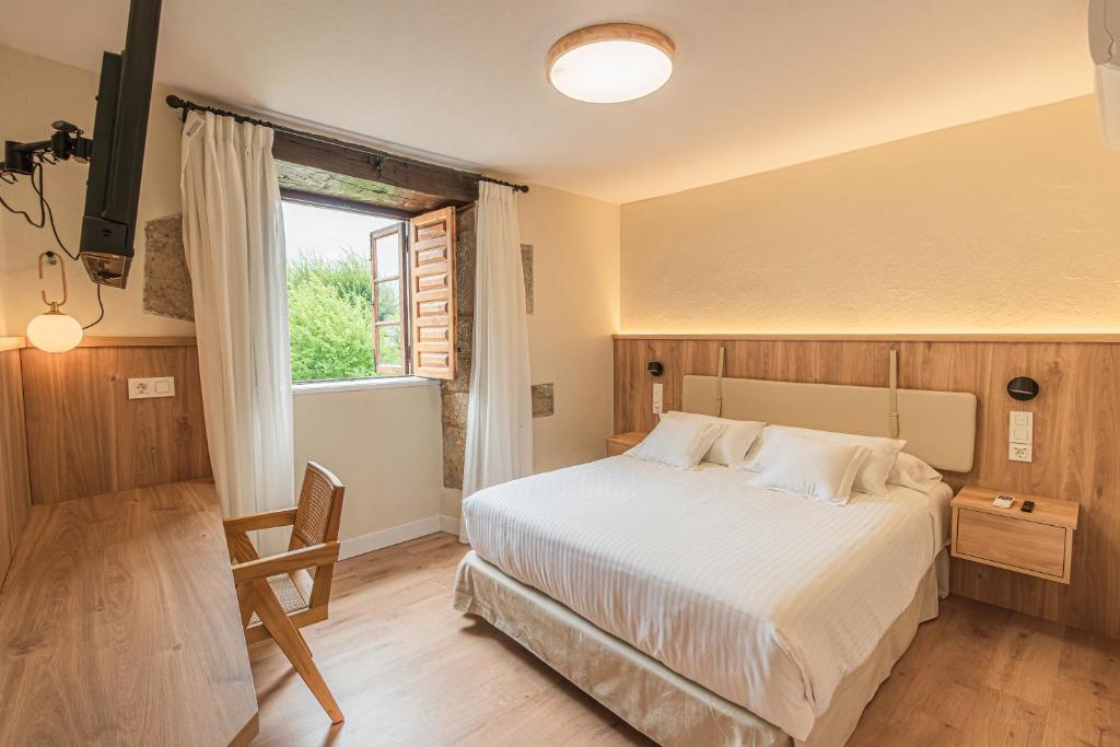 桑提亚纳德玛Hotel BESTPRICE Santillana的一间卧室设有一张大床和一个窗户。