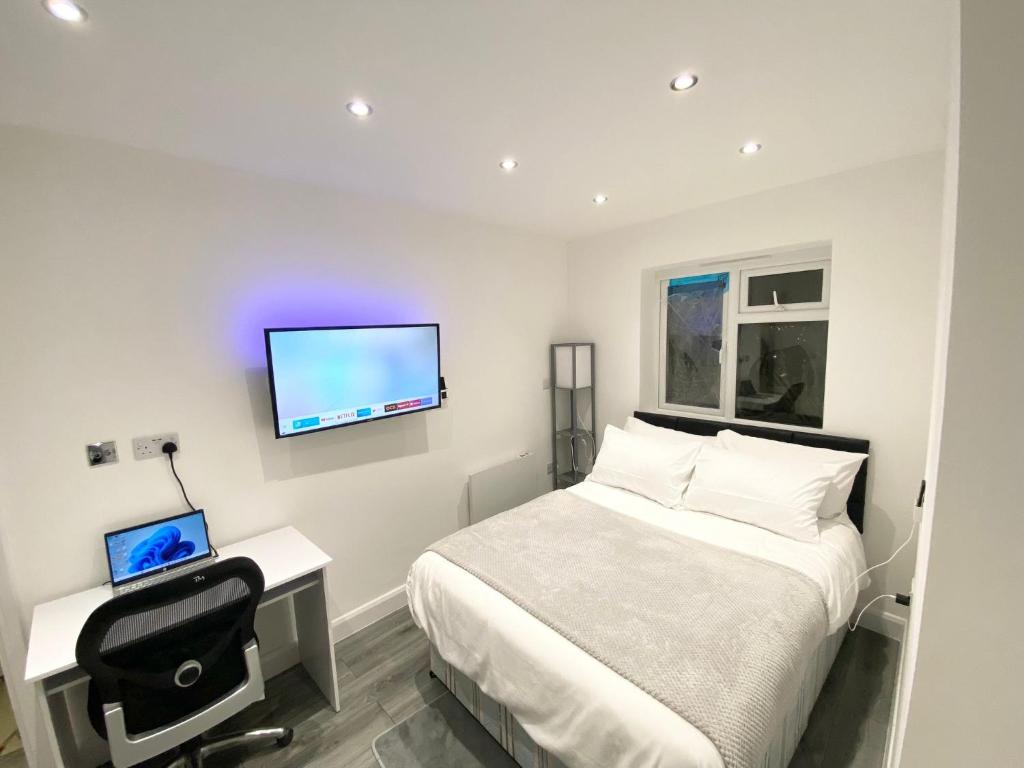 清福德London Studio的一间卧室配有一张床、一张书桌和一台电视。