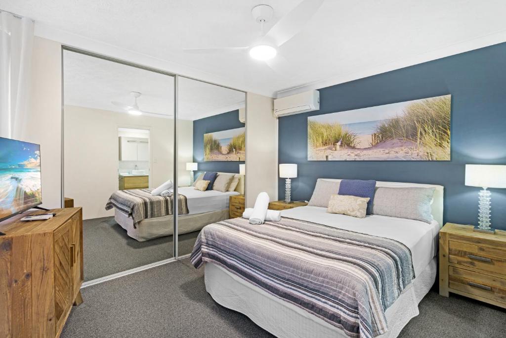 黄金海岸Oceanside Cove的一间卧室配有两张床和一台平面电视