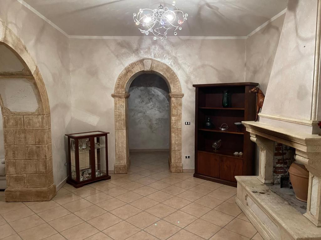 CeccanoAppartamento Marchesini的大型客房设有壁炉和吊灯。